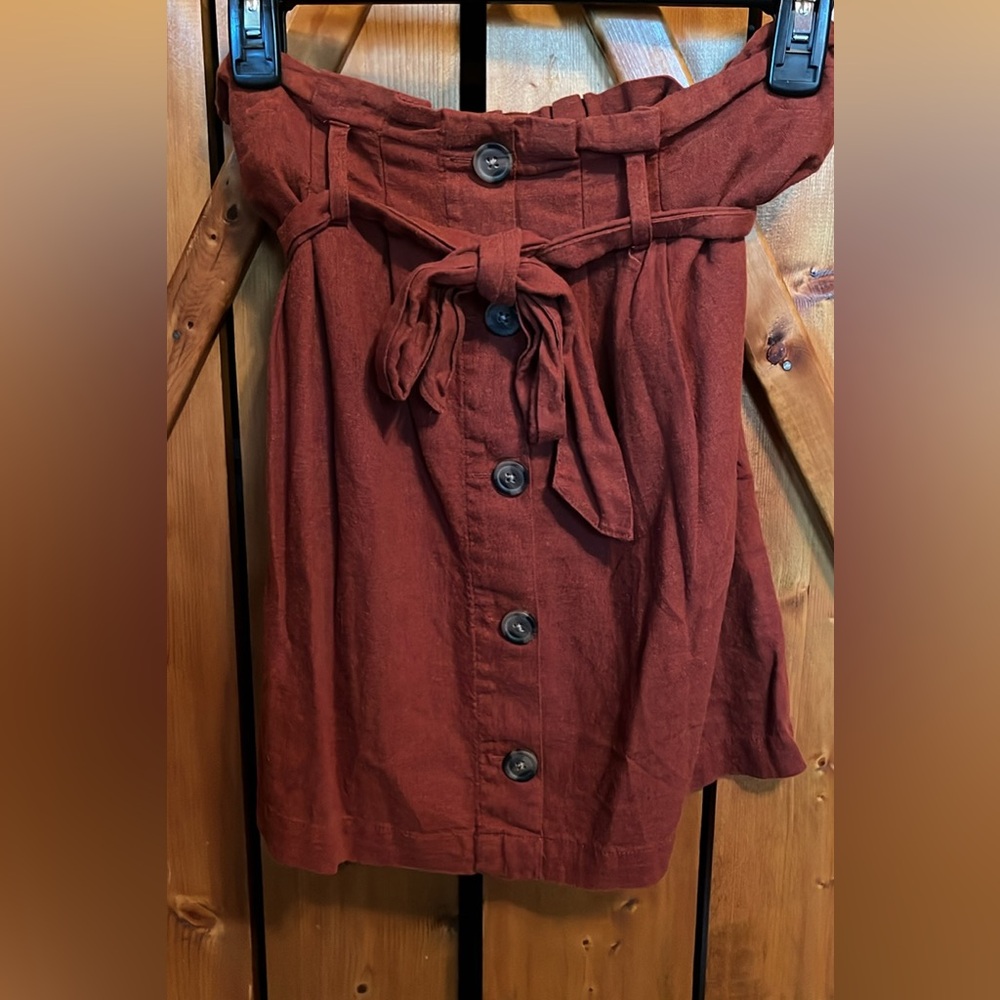 Pair of Mini Skirts. One has buttons and tie details. The other is “lacey”.